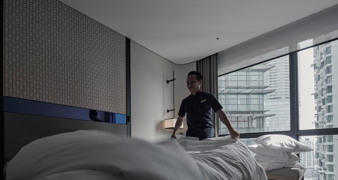 Amari Kuala Lumpur Hotel Exterior photo A hotel housekeeper making a bed